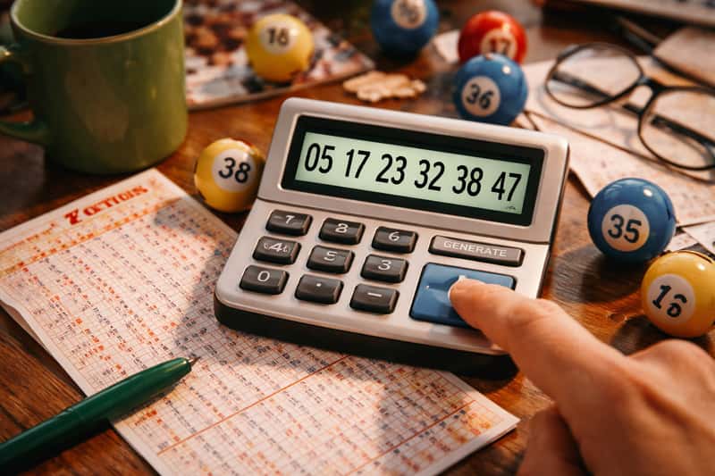 Wooden dice scattered on a numbered grid with a digital Wooden dice scattered on a numbered grid with a digital display showing six random digits in the background